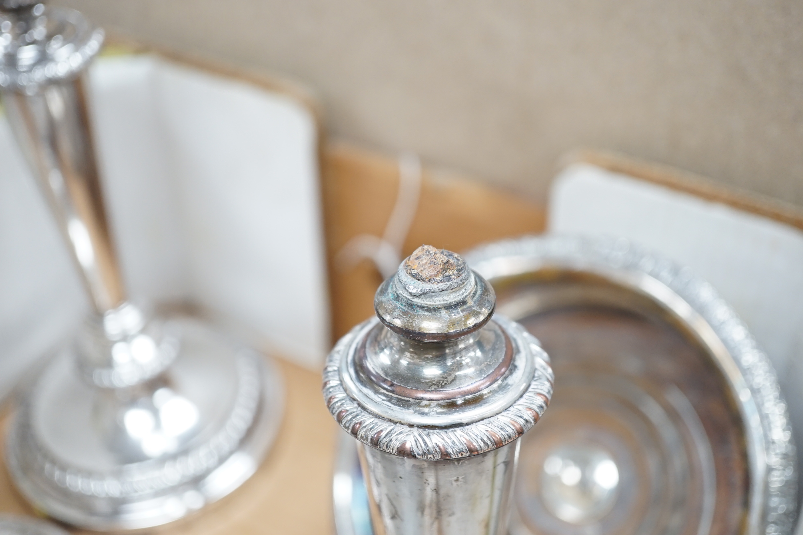 Plated wares: a pair of wine coasters, two ornate basket-edged dishes, a sugar bowl, three candlesticks, three candleholders, a teapot, ice bucket cased serving spoons and a metal mounted glass decanter.